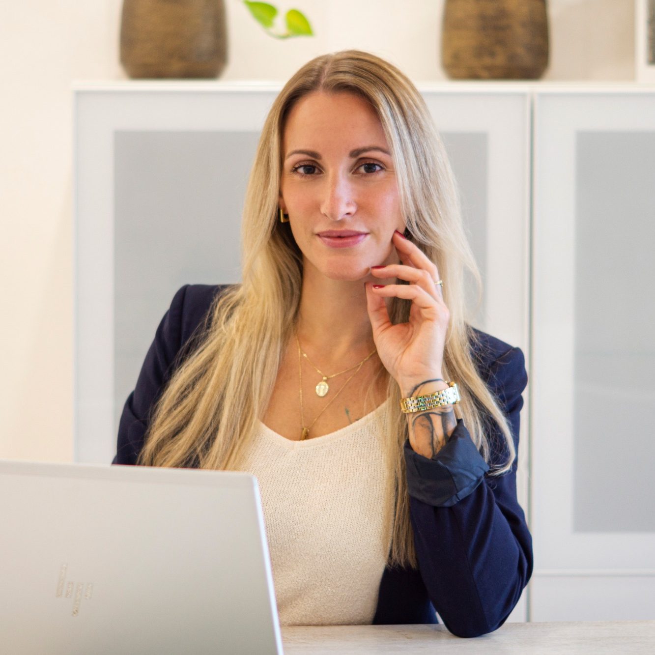 Virtuelle Assistenz Büroservice Albstadt Frau mit langen blonden Haaren, sitzt am Schreibtisch und schaut nachdenklich.